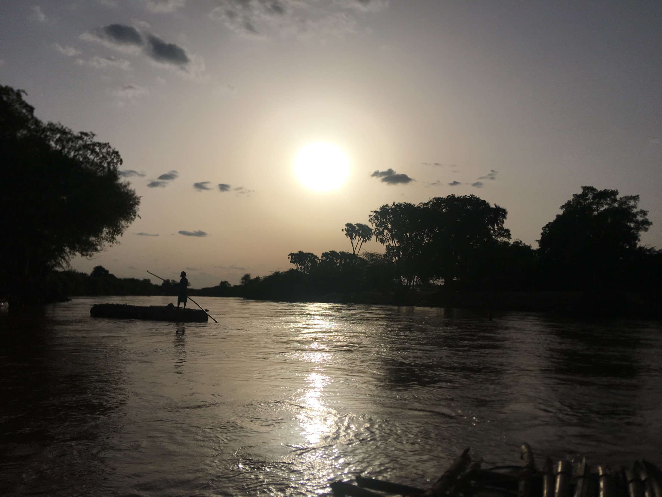 Dusk on a river, a boatman crossing in silhouette